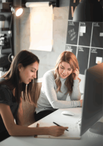 Dos profesionales trabajando juntas en estrategia digital y diseño web en un entorno de coworking moderno