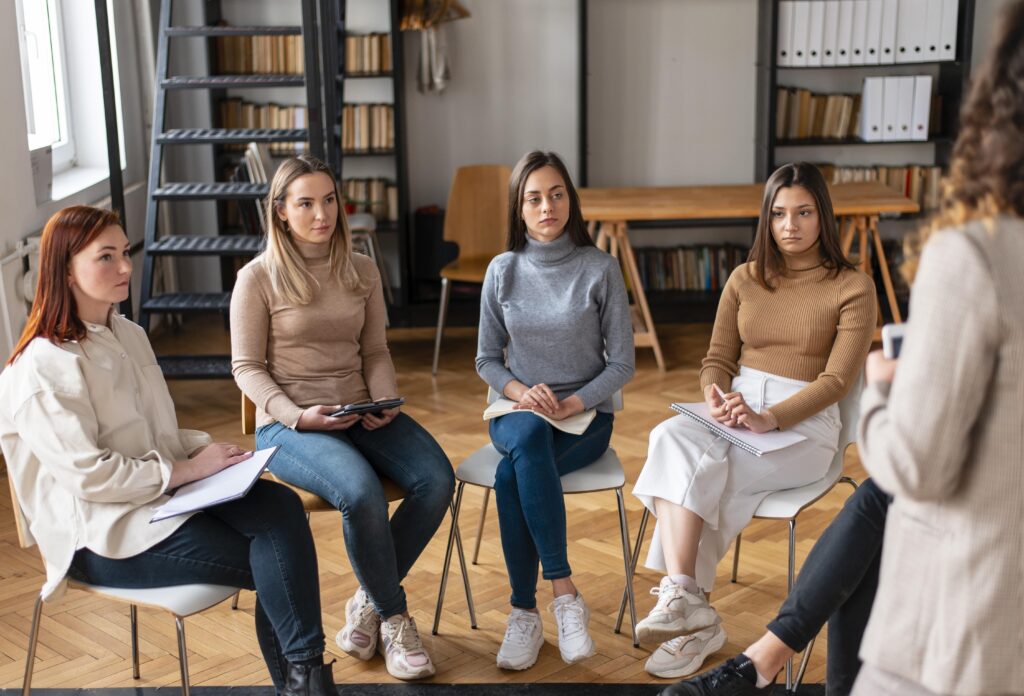 Mujeres en terapia de grupo guiada por psicóloga.