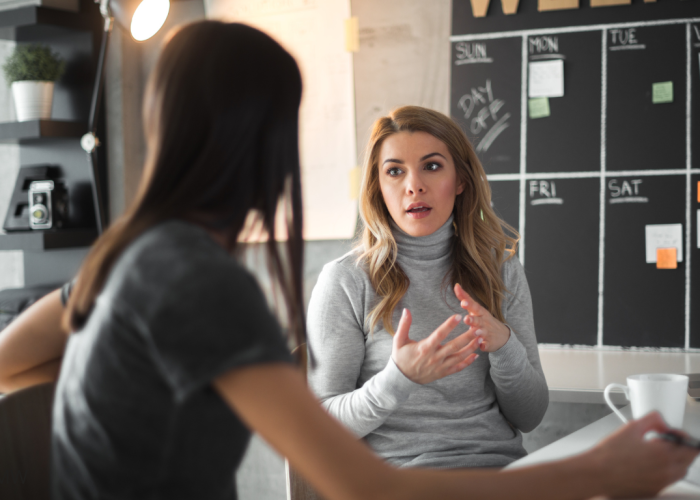 Mujer ofreciendo asesoramiento estratégico personalizado sobre diseño web y posicionamiento digital a una clienta